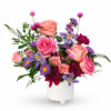 Pink and purple mixed flower arrangement in a white vase