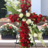 Cross-shaped floral tribute of red and white roses on an easel