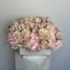 Pink roses and carnations arranged in a white rectangular vase