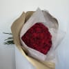 Bouquet of red roses wrapped in brown and white paper