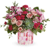Pink and blush floral arrangement in a patterned glass vase