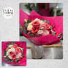 Hand-tied bouquet of pink, peach, and cream roses in bright magenta wrap, displayed in a white vase.