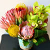 Bouquet of pink protea and green orchids in a blue vase