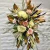 Tall floral spray with pale blooms and copper-toned foliage on a stand