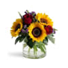Sunflowers and red roses in a clear glass vase