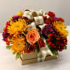 Flower arrangement in a gift box with a plaid ribbon bow