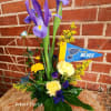 Purple irises with yellow and blue flowers in a low arrangement
