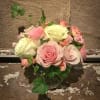 Pink and cream roses arranged in a clear glass vase