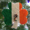 Floral tribute in green, white, and orange with a ribbon bow