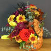 Autumn bouquet with roses, chrysanthemums, and a pumpkin vase