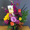 Mixed bouquet with roses, chrysanthemums, and a chocolate bar in a black vase