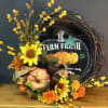 Fall wreath with sunflowers, orange blooms, and pumpkins