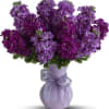 Purple flower bouquet in a lavender vase with a ribbon bow