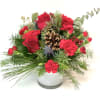 Red roses and carnations in a white vase with pine and a pinecone