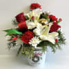 Holiday bouquet with red and white flowers in a festive bucket