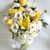 Yellow roses and white daisies in a glass vase