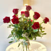 Tall bouquet of red roses in a clear glass vase