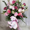 Pink and white flower arrangement with a plush bunny in a glass vase