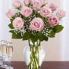 Pink roses arranged in a clear glass vase with baby's breath