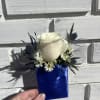 White rose boutonniere with blue ribbon wrap and small white daisies