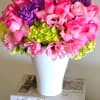 Pink and purple flower arrangement in a white vase