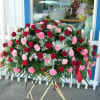 Large standing spray of red roses and pink carnations