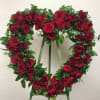 Heart-shaped wreath of red roses on a stand
