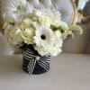 White rose and lily bouquet in a black hat box with striped ribbon