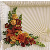 Orange and red floral spray on a white casket
