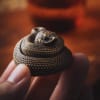 A small coiled snake figurine held between fingers