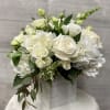 White roses and hydrangeas arranged in a square box with greenery