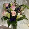 Pink roses and white lilies arranged in a clear glass vase