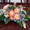 An eclectic array of fall flowers in a long low design bowl.