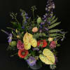 Mixed bouquet with purple, pink, and yellow flowers in a vase