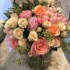 Sherbert colored roses, ranunculus and tulips.  Full and lush.  Vase