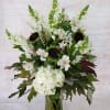 This subtle and elegant all white arrangement includes sunflowers, hydrangea, alstromeria and
