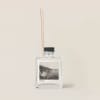 Clear reed diffuser bottle with black cap and wooden sticks