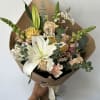 Seasonal light colored flowers arranged into a hand-tied bouquet. 