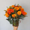 Orange and yellow mixed bouquet in a clear glass vase