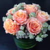 A pretty arrangement including pink roses and green succulents