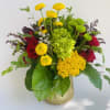 Mixed bouquet of red roses and yellow chrysanthemums in a gold vase
