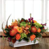 Exquisite garden table centerpiece featuring garden roses, orange protea, berry stock, garden