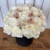 White roses and orchids arranged in a black box
