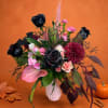 Bouquet of black and pink flowers in a white vase with autumn decor