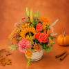 Autumn bouquet with sunflowers, roses, and mums in a white basket