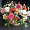 Mixed bouquet in a birch container with pink, white, orange, and purple flowers