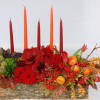 A rich table centerpiece of amarilis, scabiosa pods, green dianthus, roses, tulips