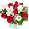 Red roses and white calla lilies in a clear glass vase