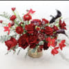 Red roses and calla lilies arranged in a low vase