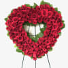 Heart-shaped wreath of red roses on a stand